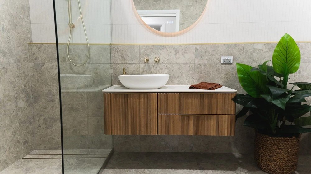 Main bathroom with a timber floating vanity and wall mounted brass tapware