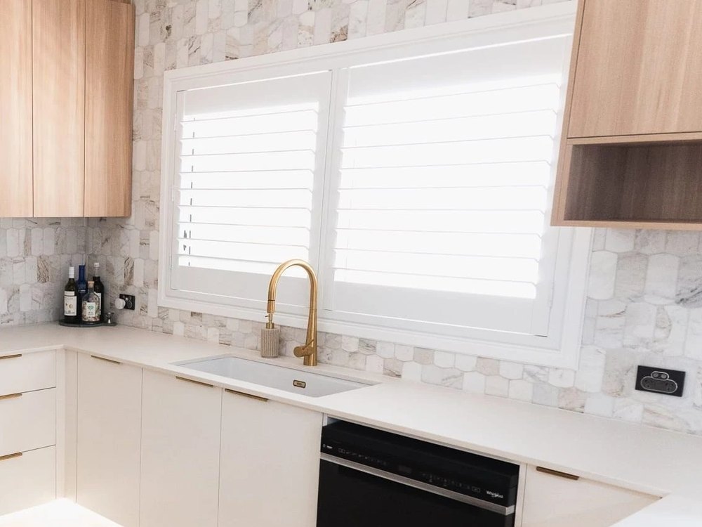 Stone splashback meeting the timber overhead cabinetry
